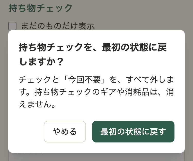 確認のダイアログ。見出し「持ち物チェックを、最初の状態に戻しますか？」、本文「チェックと「今回不要」を、すべて外します。持ち物チェックのギアや消耗品は、消えません。」、ボタンは「やめる」と「最初の状態に戻す」